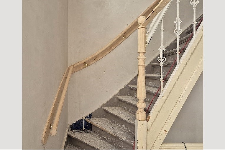 Grenen trapspil en muurleuning.