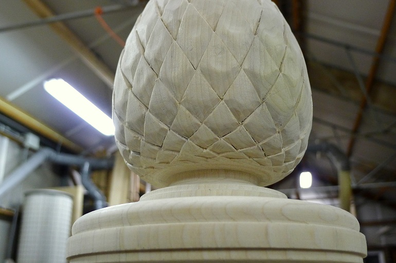 Handgesneden dennenappel in Yellow Poplar voor de bekroning van de trappaal. Handgesneden dennenappel in Yellow Poplar voor de bekroning van de trappaal.